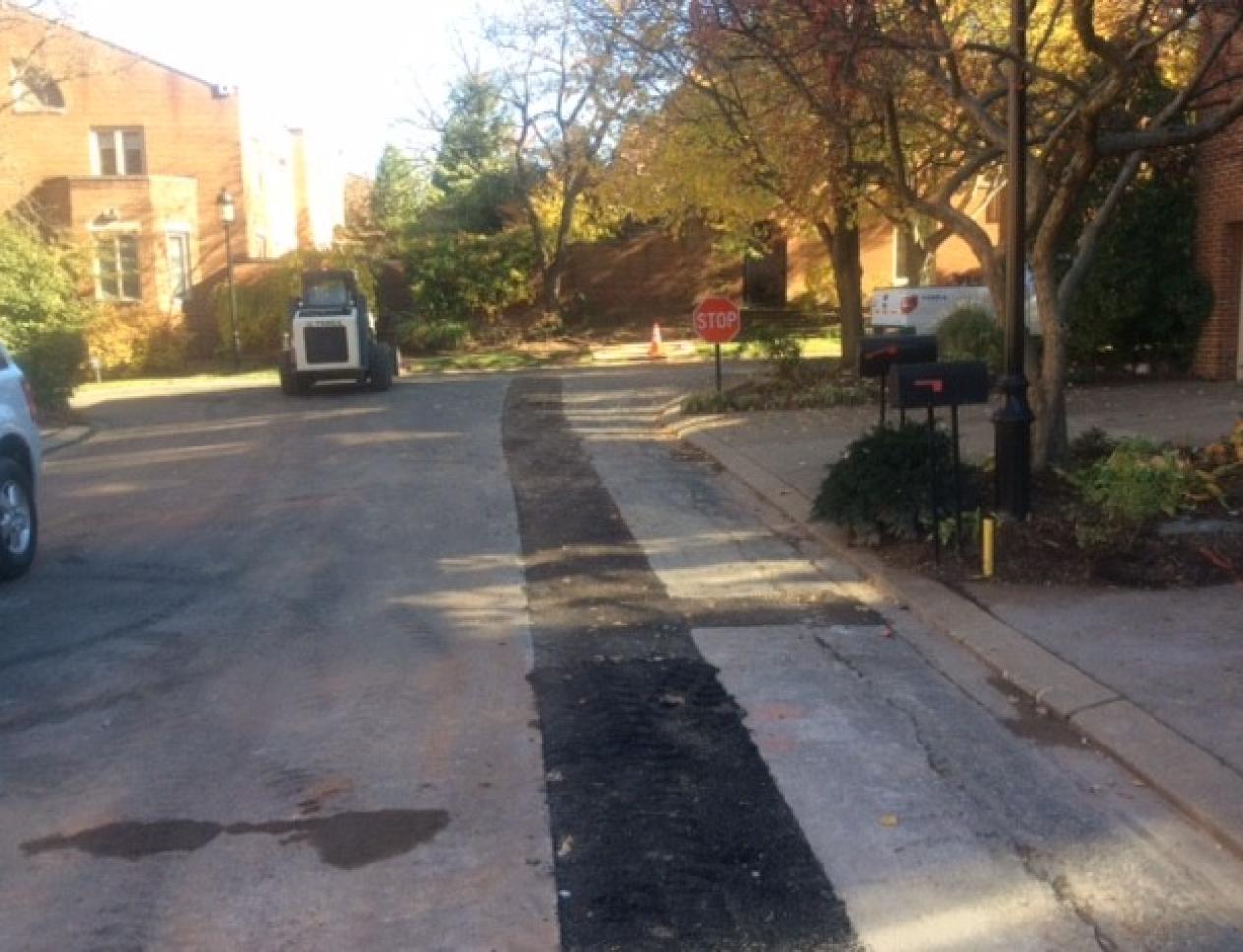 Residential street with temporary patching during utility work.