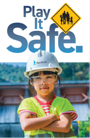 Young child wearing a Peoples-branded hard hat and safety vest stands confidently with arms crossed beneath the words “Play It Safe,” promoting safety awareness.
