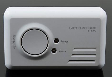 Carbon monoxide alarm with test/reset button, power and alarm indicator lights, and front ventilation slots.